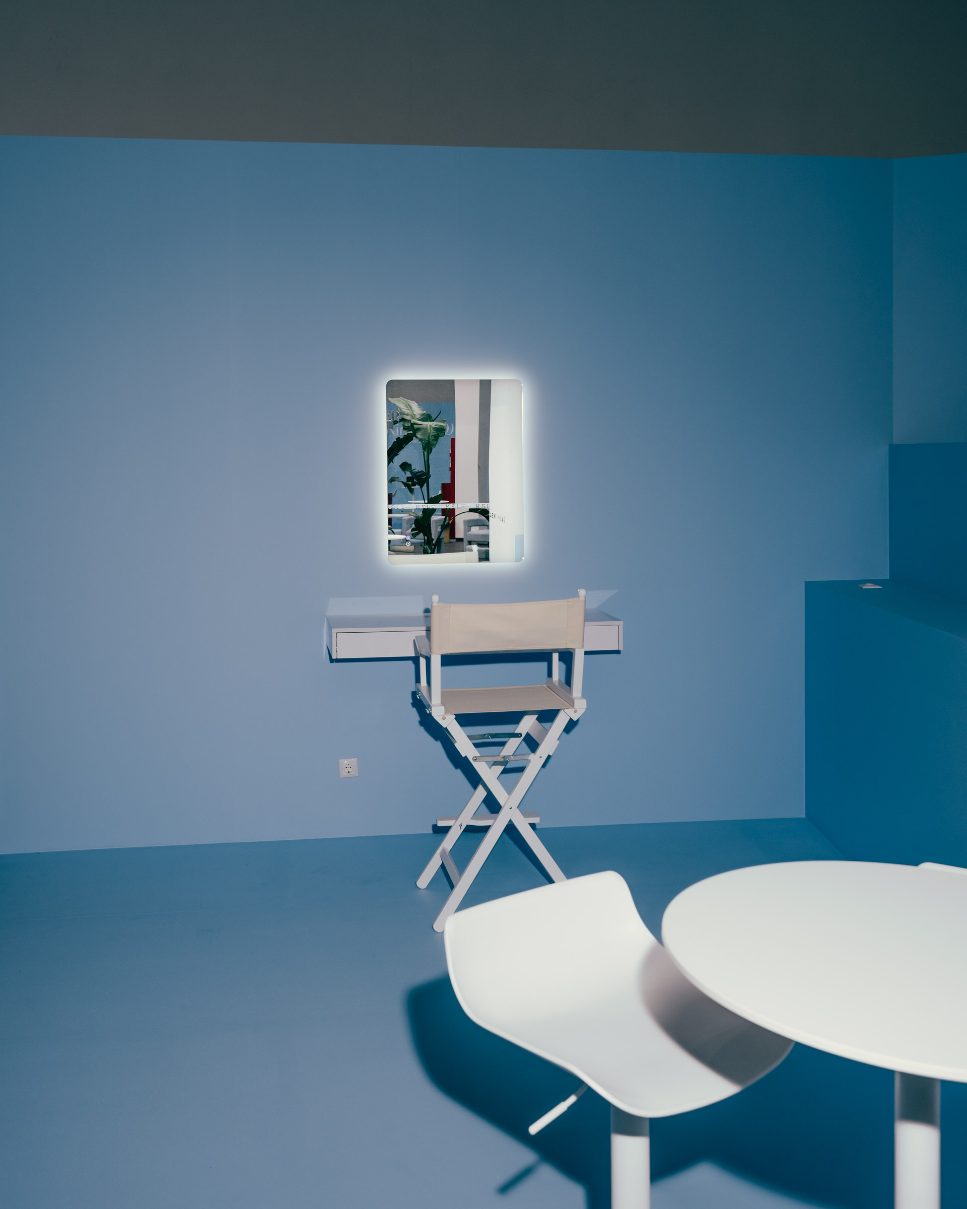 Minimalist room with makeup vanity, chair, and table. 