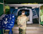 Soldat lernt Knoten an einem Ausstellungsstand.