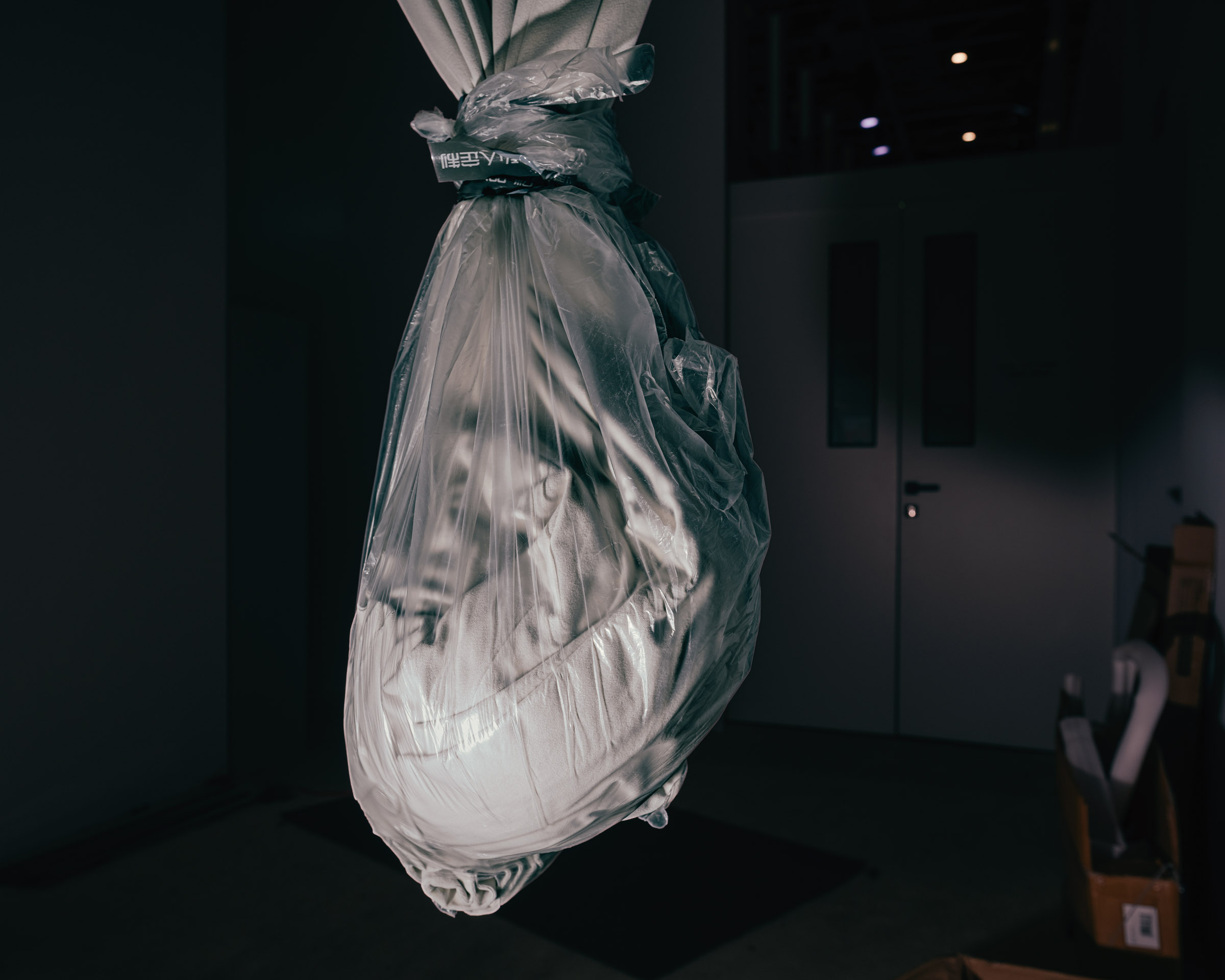 Stoff in Plastikfolie hängt von der Decke. 
