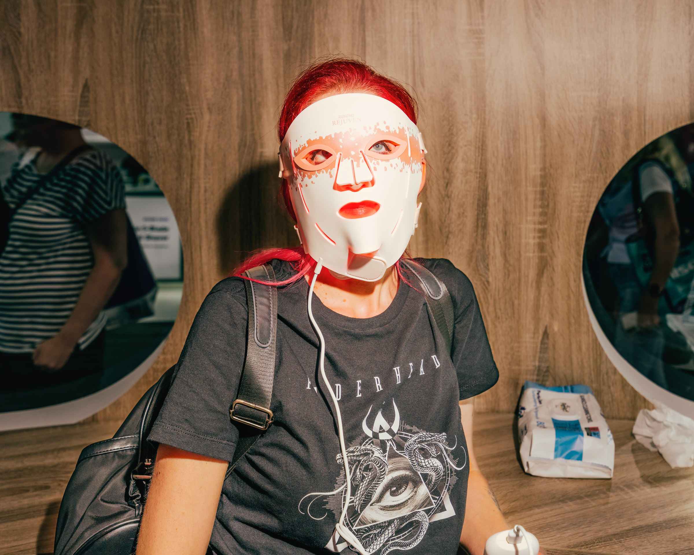 Frau mit leuchtender Gesichtsmaske und roten Haaren. 