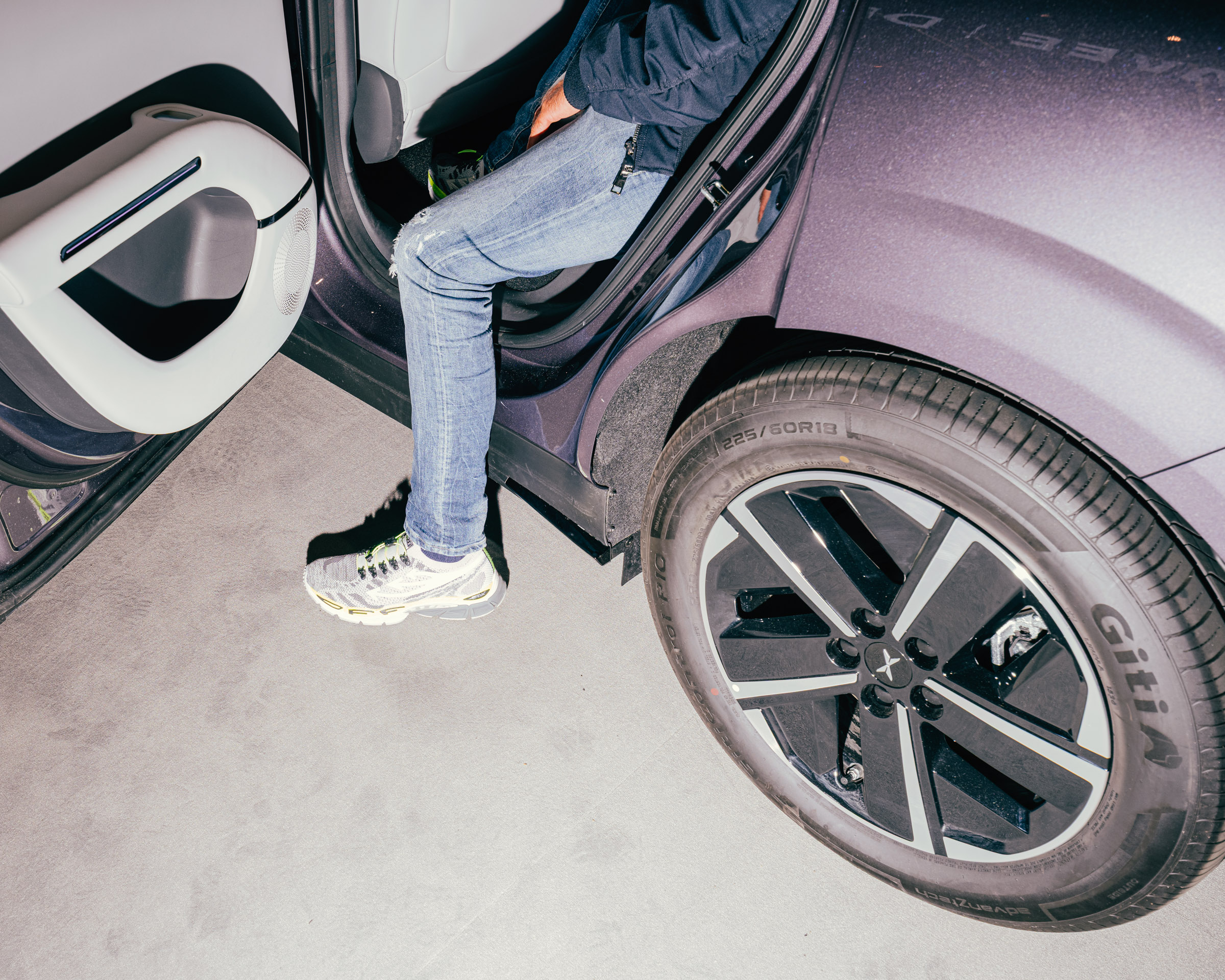 Person steigt in ein Auto, Nahaufnahme des Rades. 