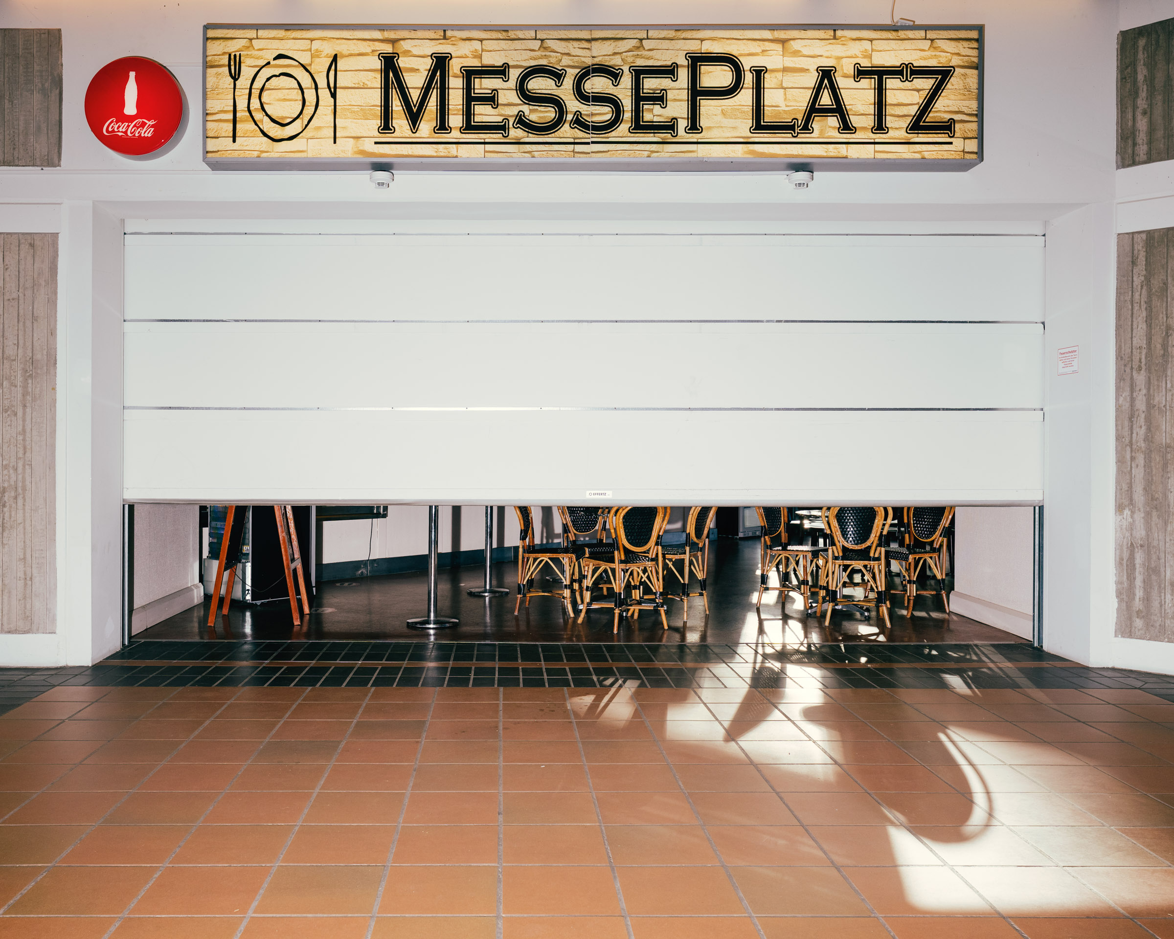 Messeplatz: Restaurant mit Stühlen und Tischen. 